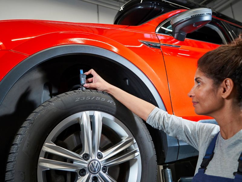 VW service employee measures tread depth of a VW tyre