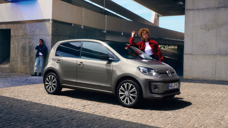 Ragazza appoggiata a Volkswagen up! con "white style" Pack