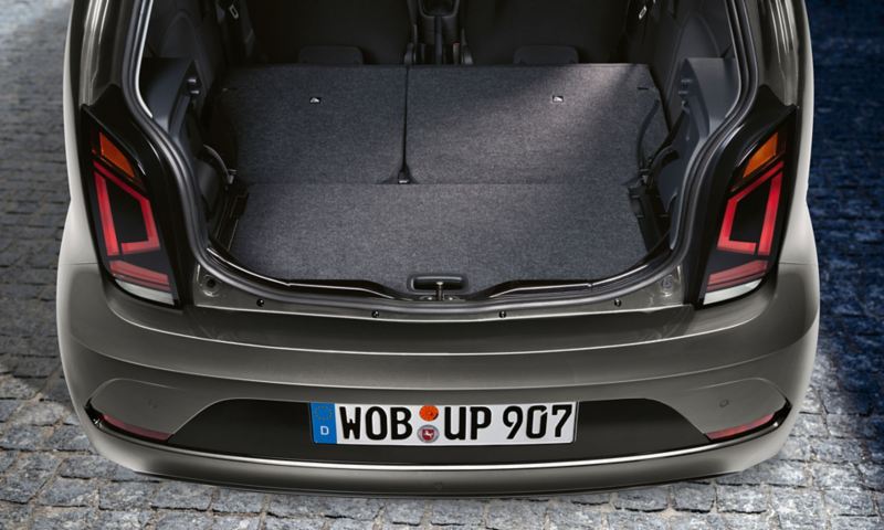 Grauer VW up! Black Style, Blick in den geöffneten Kofferraum mit umgeklappter Rücksitzlehne