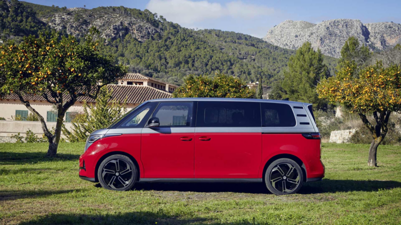 En röd VW ID. Buzz GTX med fyrhjulsdrift uppställd på en gräsmatta.