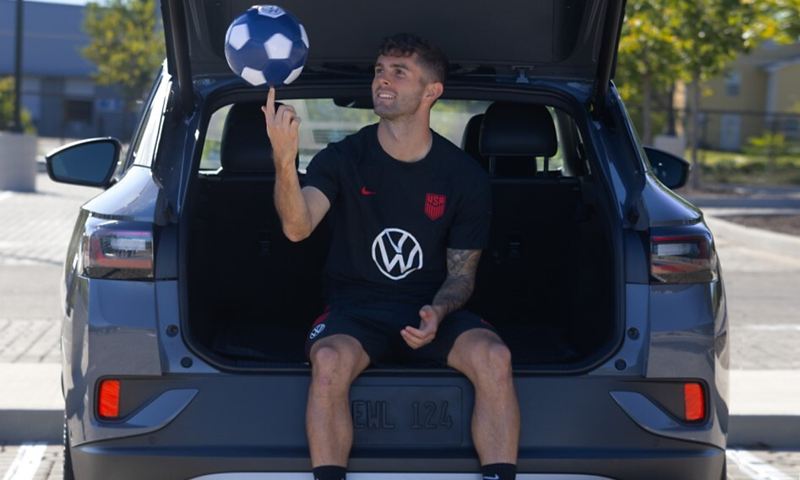 Soccer player sitting on tailgate of ID.4.