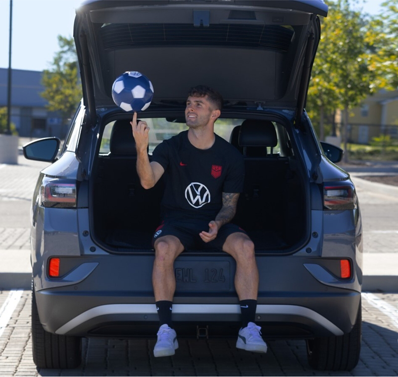 Soccer player sitting on tailgate of ID.4.