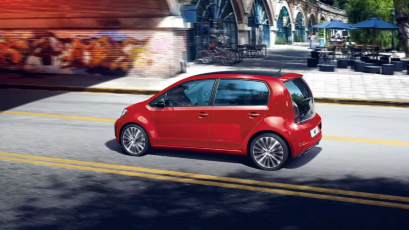 Red VW up! driving through a street