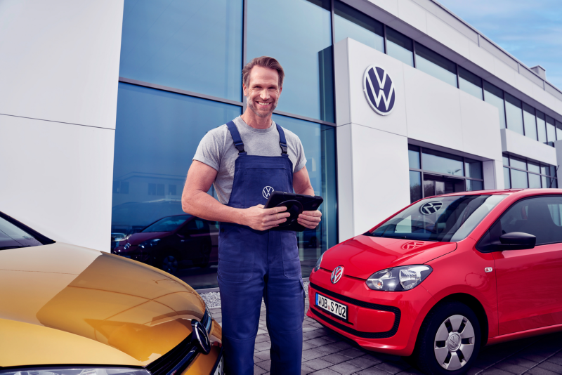 Un employé de service se tient devant un garage