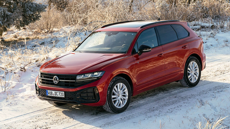 a red VW Touareg on a snowy countryside road