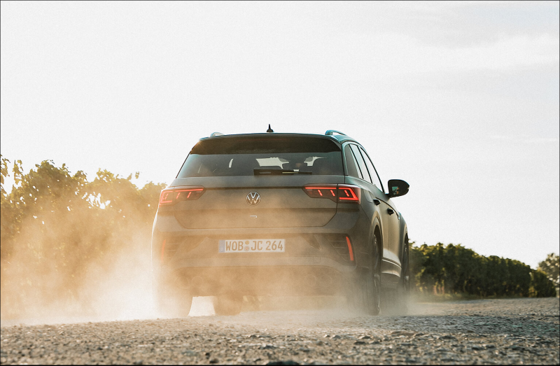 Volkswagen SUV driving on a dusty gravel road.