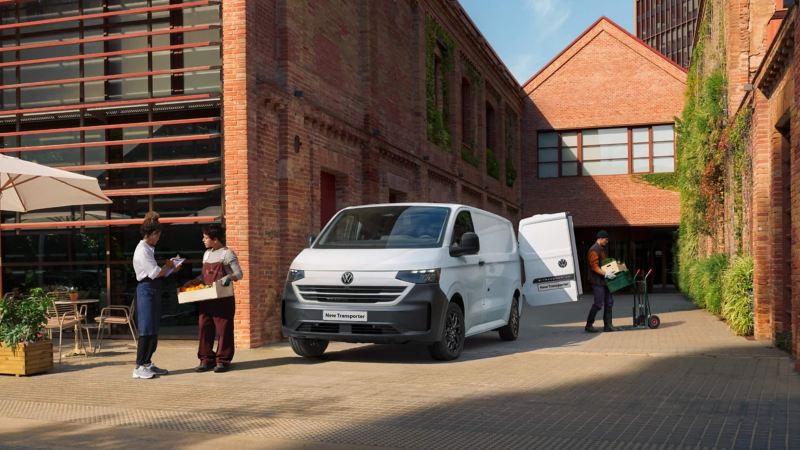 New Transporter parked and being unloaded outside of a restaurant.