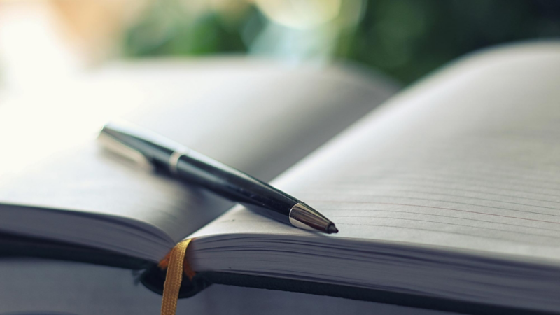Close-up of a ballpoint pen on an open notebook