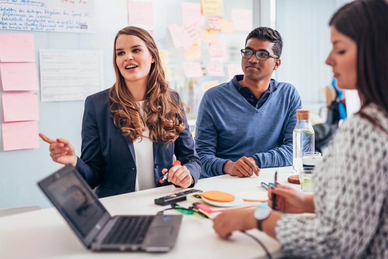 Zwei Frauen und ein Mann arbeiten an einem Projekt