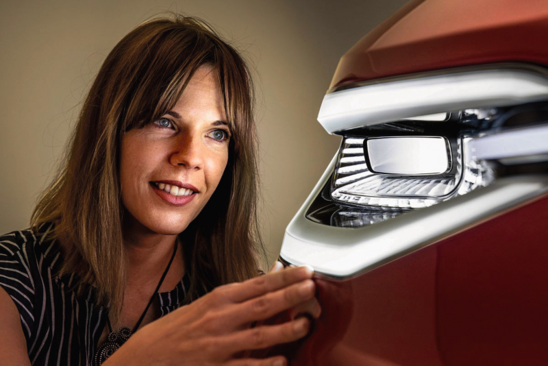 Woman looking at a front light of a car