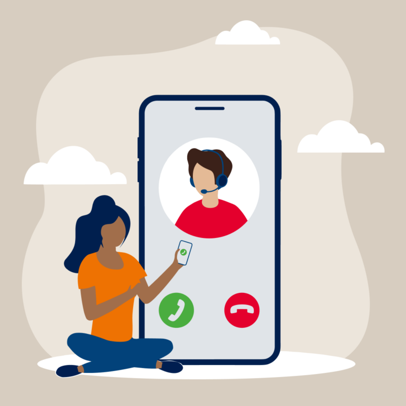 Symbolbild für Volkswagen Hotline: Frau sitzt vor körpergroßem Telefon mit Hotline-Preview