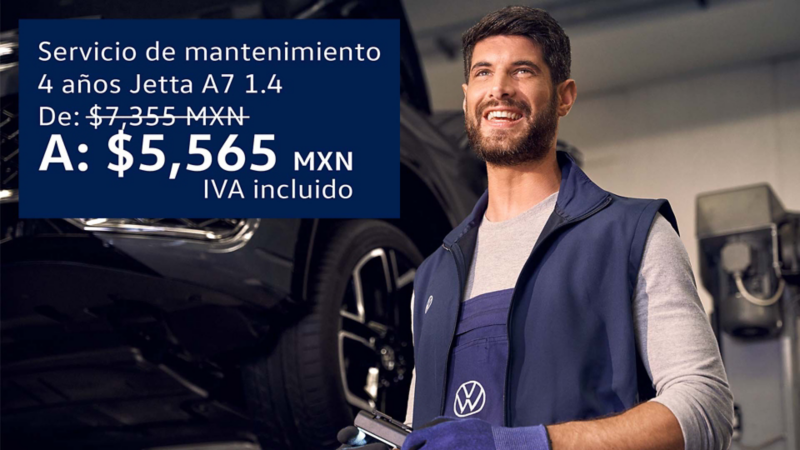 Técnico de Volkswagen sonríe mientras da mantenimiento a un auto VW. 