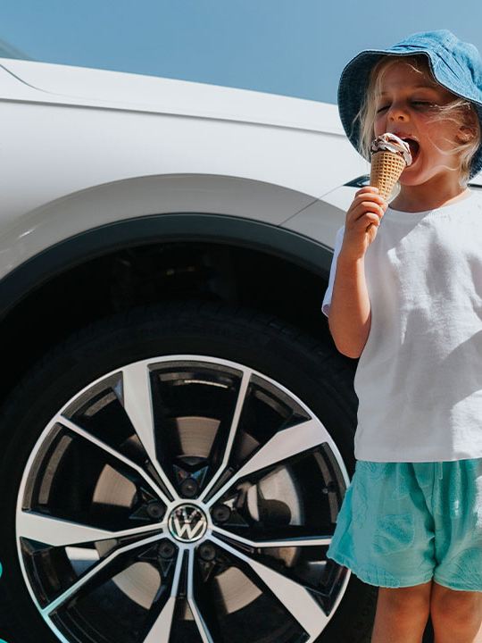 Family walking around Volkswagen Tiguan Allspace which is parked on the rooftop.