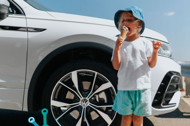 Family walking around Volkswagen Tiguan Allspace which is parked on the rooftop.