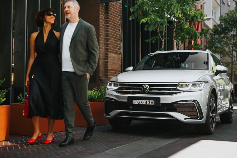 Couple walking in front of the Tiguan