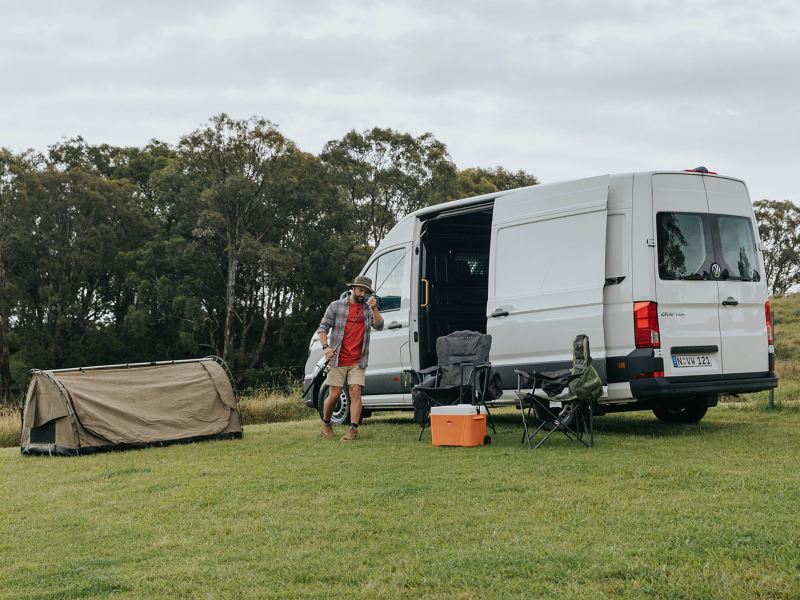 Volkswagen Crafter van parked with camping setup.