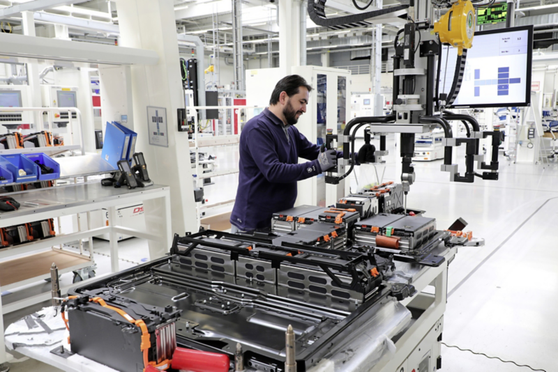 Mitarbeiter in der Batteriefertigung bedient eine Maschine