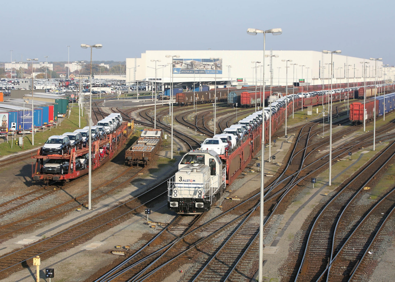 Werkeisenbahn mit Autos auf Waggons