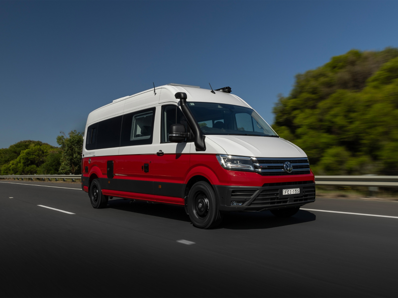 Red and white Kampervan driving on road
