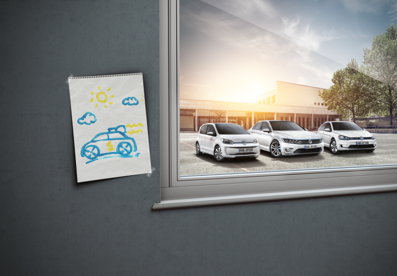 rysunek auta przyklejony na ścianie, w tle za oknem widać zaparkowane trzy białe volkswageny