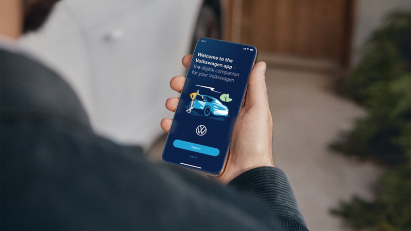 Person looking at a mobile phone and using the Volkswagen app