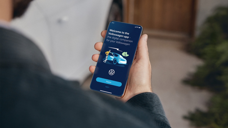 Une personne regarde un téléphone mobile et utilise l’application Volkswagen