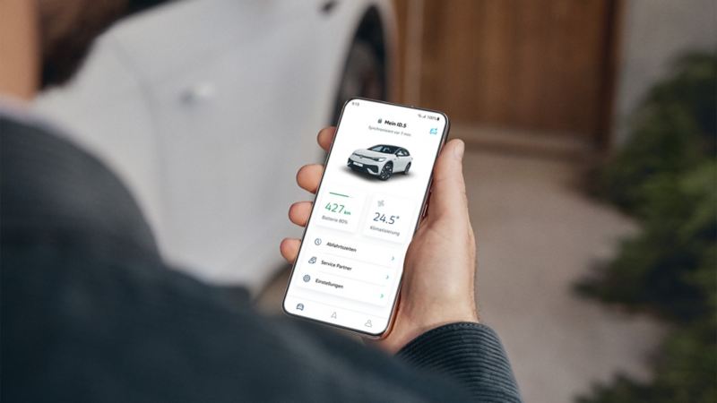 Person looking at a mobile phone and using the Volkswagen app
