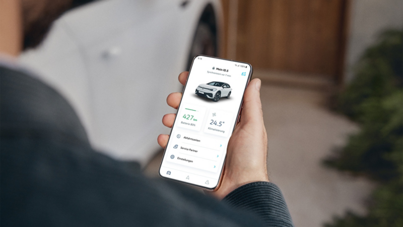 Person kigger på en mobiltelefon og betjener Volkswagen-appen