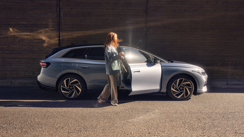 en kvinne stiger inn i passasjersetet på vw id7 tourer