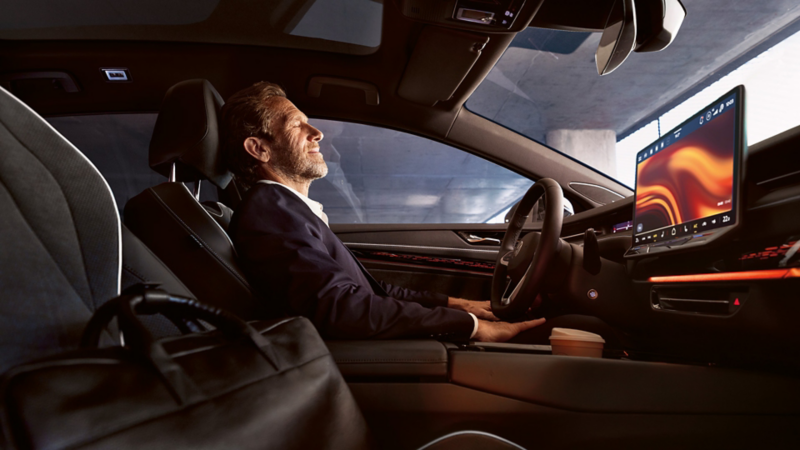 Hombre se relaja en su Volkswagen gracias a los ajustes de temperatura, asiento e iluminación del vehículo mediante la Wellness App.