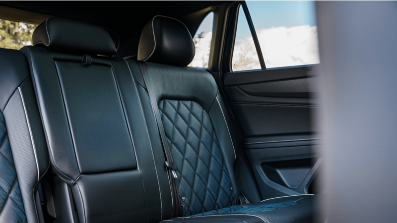 Collage of five images showcasing the Volkswagen Atlas Cross Sport, including front and rear exterior views, close-up of the wheel, panoramic sunroof, and interior dashboard with infotainment system.