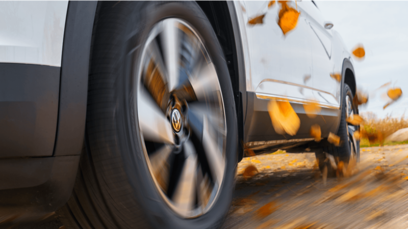 Collage of five images showcasing the Volkswagen Atlas Cross Sport, including front and rear exterior views, close-up of the wheel, panoramic sunroof, and interior dashboard with infotainment system.