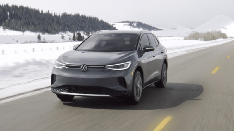 Volkswagen ID.4 driving on a snowy mountain road, showcasing winter performance and German engineering.
