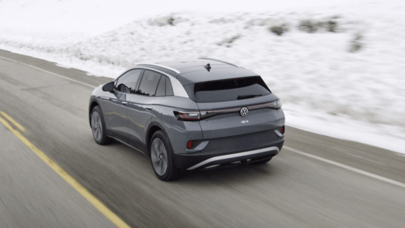 Rear view of a Volkswagen ID.4 driving on a snowy road in winter conditions. 