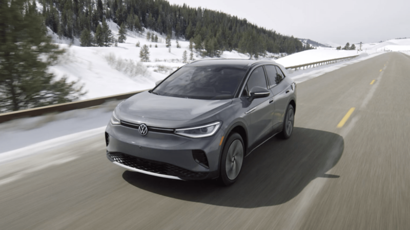 Volkswagen ID.4 driving on a clear mountain road in winter conditions. 