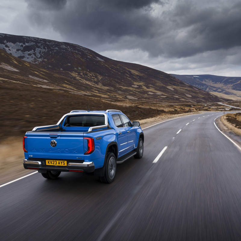 Photo of a blue Amarok parked against a countryside background. 