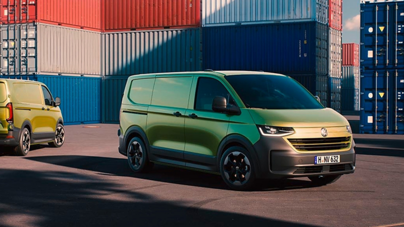 VW Transporter Kastenwagen parkt vor Containern.