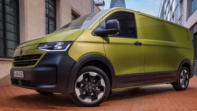 VW Transporter Kastenwagen parkt zwischen Gebäuden in einer Stadt.