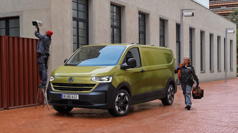 Handwerker:innen parken mit VW Transporter vor einem Gebäude um an einem Video-Überwachungssystem zu arbeiten.
