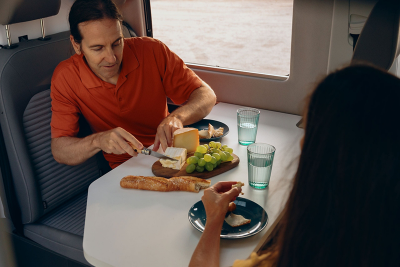 homme qui mange du camembert dans le Grand California VW