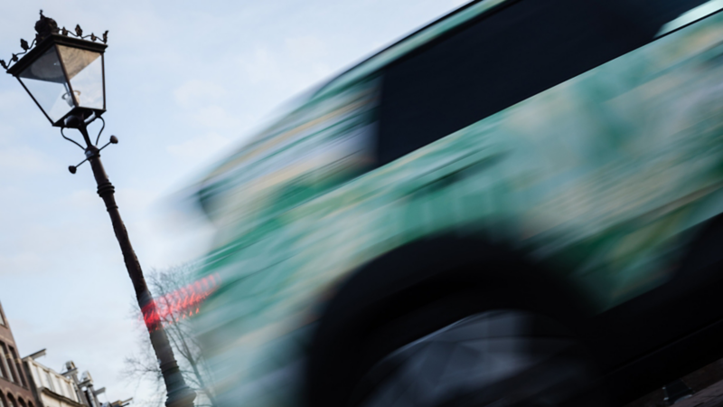 Ein VW Cross mit Konzeptbeklebung fährt dynamisch vorbei an einer Laterne.