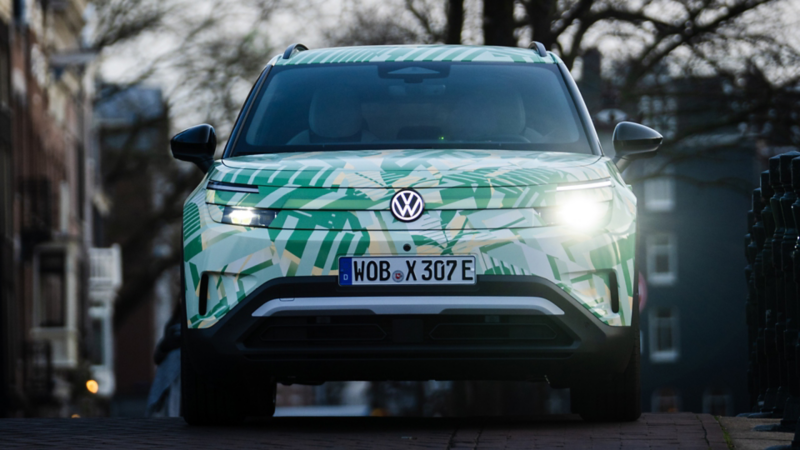 Ein VW ID. Cross mit Konzeptbeklebung von vorne auf einer urbanen Strasse.
