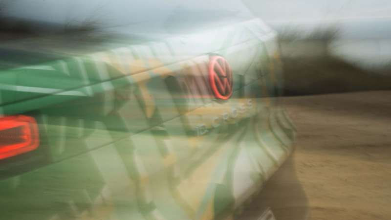 Detailansicht der Rückleuchten eines fahrenden VW ID. Cross mit Konzeptbeklebung.