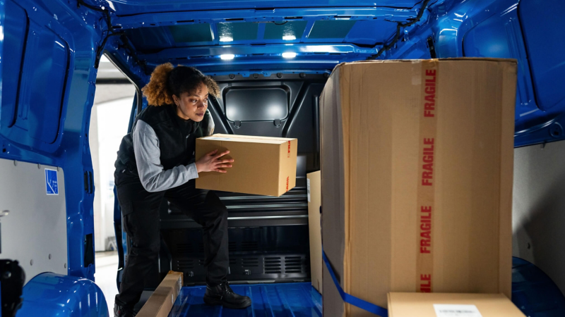 a woman loading a Transporter van with boxes