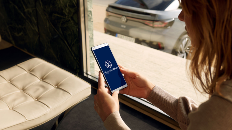 Une femme lance une application Volkswagen sur son téléphone portable