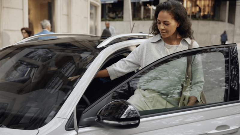Une femme monte à l'intérieur de la Volkswagen ID.4 grise