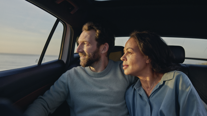 Un homme et une femme regardant par la fenêtre alors qu'ils étaient assis dans la voiture