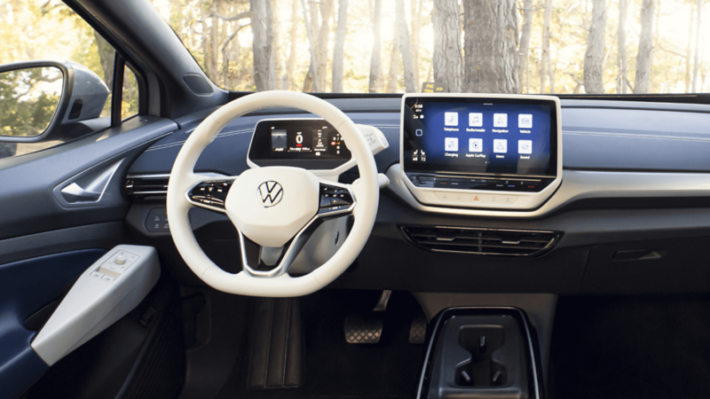L'intérieur de la voiture Volkswagen avec un volant et un tableau de bord blancs
