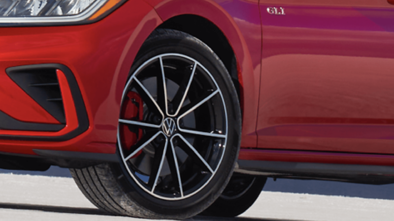 Close-up of the 2026 Jetta GLI’s alloy wheel design with red brake caliper and GLI badge detail.