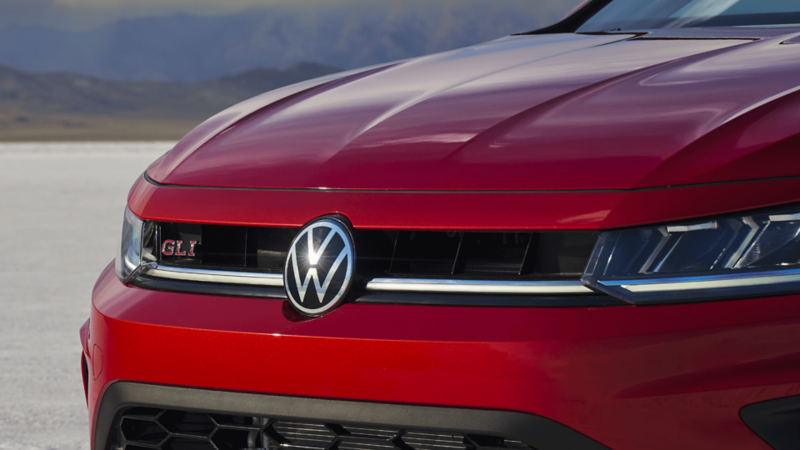 Close-up of the GLI badge and front grille on the 2026 Jetta GLI in red.